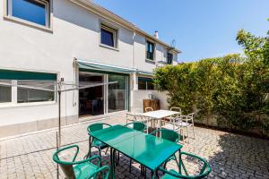 a patio with a table and chairs in front of a building at Lisbon Casa da Clementina - a Serene Garden Stay in Lisbon