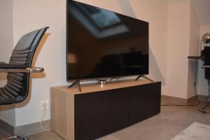 a flat screen tv sitting on top of a cabinet at Appartement-terrasse parking privé Meublé de Tourisme 4 étoiles in Belfort
