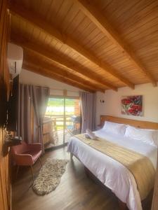 a bedroom with a large bed and a balcony at El Encanto de Antilhue in Valdivia