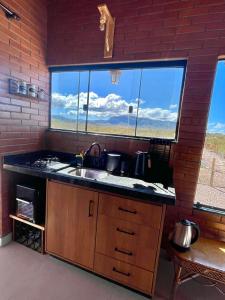 a kitchen with a sink and a large window at Nosso Quintal na Chapa da in Alto Paraíso de Goiás