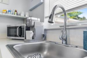 a kitchen counter with a sink and a microwave at Cozy Casarita Cottage in Miami