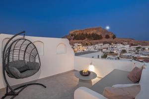 a living room with a couch and a chair at Noema Lindos - Agapitos Apartment in Lindos