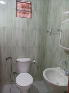 a bathroom with a white toilet and a sink at Siete aconchego in Porto Seguro