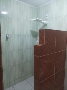 a shower with a shower head in a bathroom at Siete aconchego in Porto Seguro