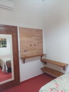 a room with a mirror and a shelf on the wall at Siete aconchego in Porto Seguro