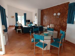 a living room with a table and blue chairs at Ocean Villa Algarve in Alvor
