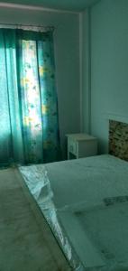 a bedroom with a bed and a window with a curtain at Apto com charme conforto vista e completo in Florianópolis