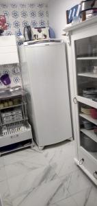 a kitchen with a white refrigerator and an open door at Apto com charme conforto vista e completo in Florianópolis