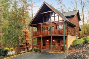 a cabin in the woods with a large deck at Cozy 5BR Cabin Near Dollywood in Pigeon Forge