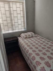 a bedroom with a bed and a window with a bedspread at Departamento Copacabana in Viña del Mar