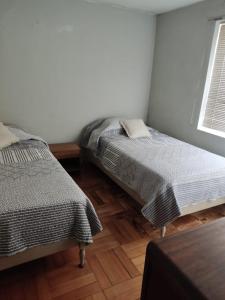 a bedroom with two beds and a window at Departamento Copacabana in Viña del Mar