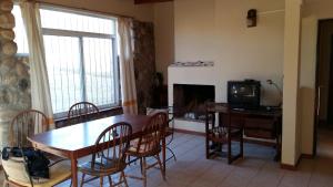 a living room with a dining room table and a tv at Casa Despertares - Las Rabonas in Mina Clavero