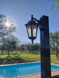 a black lamp post next to a pool at soy ahora primera in Pueblito