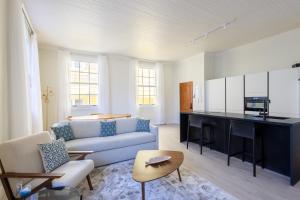 Una sala de estar con un sofá y una cocina. en Broadway Apartments - Chic & Stylish Urban Stays, en Willemstad