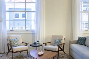 sala de estar con 2 sillas y sofá en Broadway Apartments - Chic & Stylish Urban Stays, en Willemstad