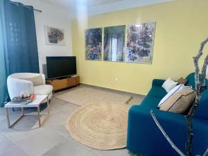 RémiréApt 1 chb belle déco résidence avec piscine的客厅里有一张蓝色沙发和一台电视