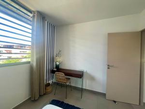 RémiréApt 1 chb belle déco résidence avec piscine的一间卧室设有书桌和窗户。