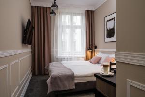 um quarto de hotel com uma cama e uma janela em Imagine Apartments na Cracóvia