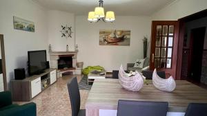 een woonkamer met een tafel met stoelen en een televisie bij West coast dream Nazare in Nazaré +52 foto's