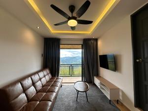 a living room with a couch and a ceiling fan at Bayu Senja Lodge in Kampong Kundassan