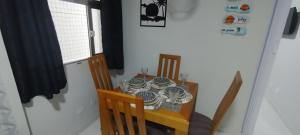 a dining room with a table with plates on it at Pé na Areia Gonzaguinha Perto de Tudo in São Vicente