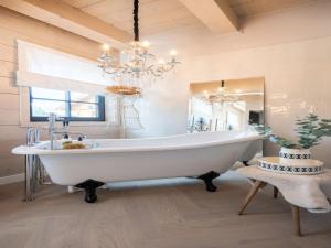 uma casa de banho com uma grande banheira branca e um lustre em Villa in Abertamy near Klinovec Ski Resort em Abertamy