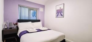 ein Schlafzimmer mit einem Bett mit zwei Handtüchern darauf in der Unterkunft Charming 3-Bedroom Home Near NEC, Birmingham Airport & Bullring in Birmingham