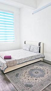 a bed in a room with a window and a rug at Tara Lodgemuslim Homestay Putrajaya in Putrajaya