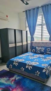a bedroom with a bed with a blue comforter at Tara Lodgemuslim Homestay Putrajaya in Putrajaya