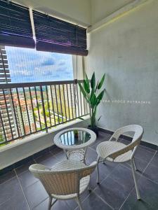 a balcony with two chairs and a table and a window at Tara Lodgemuslim Homestay Putrajaya in Putrajaya