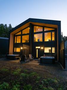 a large glass house with a bed in front of it at Calmwater Retreat New 2 br Hot Tub in Ucluelet