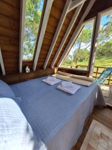 a large bed in a room with a large window at Casa na árvore perto da praia in Imaruí