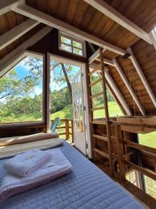 a bedroom with a bed and a large window at Casa na árvore perto da praia in Imaruí +56 photos