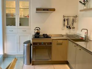ウルバーストンにあるSouth Lakes Townhouse with Saunaのシンクとコンロのあるキッチン トップオーブン