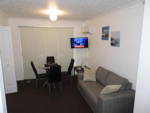 - un salon avec un canapé et une table dans l'établissement Costa D'Ora Holiday Apartments, à Gold Coast
