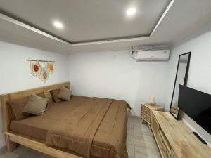 a bedroom with a bed and a flat screen tv at LaJimbar Villa Sanur Bali in Ketewel +3 photos