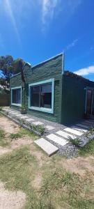ein grünes Haus mit einem Hund im Fenster in der Unterkunft AQUAMARINE in Balneario Buenos Aires