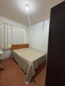 una piccola camera da letto con un letto in una stanza di Casa temporada Passo de Torres a Passo De Torres