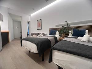 a bedroom with two beds with blue and white pillows at Sorolla Urban Suites in Valencia