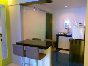 a kitchen with a black table and chairs and a refrigerator at Malacca Hotel Apartment in Melaka