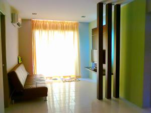 a living room with a chair and a large window at Malacca Hotel Apartment in Malacca