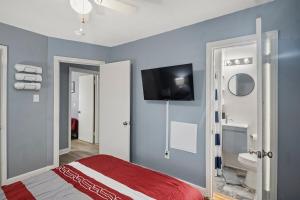 una camera da letto con un letto e una TV a parete di Central RVA Home 4 Bed, 3 Bath Getaway! a Richmond