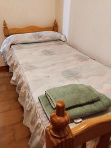 a bedroom with a bed with a green blanket on it at Balcón crucero in Granada