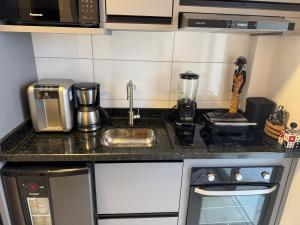 a kitchen with a sink and a counter top at Apartamento novo em Matinhos 2 piscinas in Matinhos +14 photos