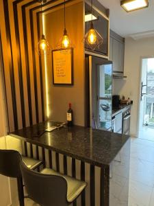 a kitchen with a table with a bottle of wine at Apartamento novo em Matinhos 2 piscinas in Matinhos