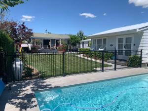 ein Haus mit einem Zaun und einem Pool in der Unterkunft Kings Cottage in Cambridge