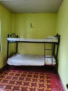 two bunk beds in a room with a letter l at HOME of ELLAI in Banga