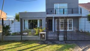 a house with a gate in front of it at Casa con piscina y jacuzzi en santa clara del mar in Santa Clara del Mar
