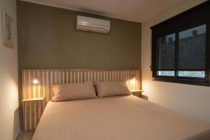 a bedroom with a bed with two lamps and a window at Complejo Solares in Alta Gracia +27 photos