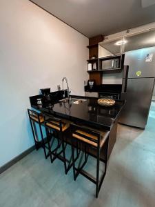 a kitchen with a sink and a refrigerator at Resort Xangri-la Piscina aquecida in Xangri-lá